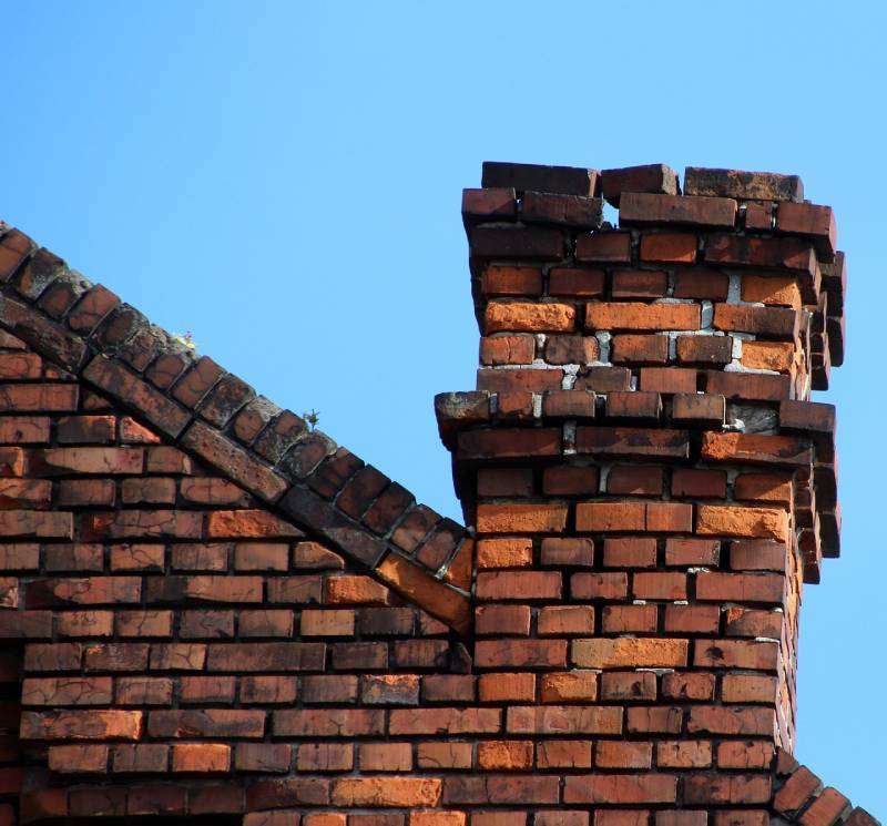 Damaged chimney on an Attleboro home showing cracks and missing mortar